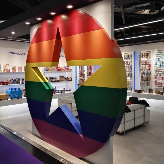 Installazione con stella arcobaleno in un negozio di giocattoli, circondata da scaffali pieni di prodotti.