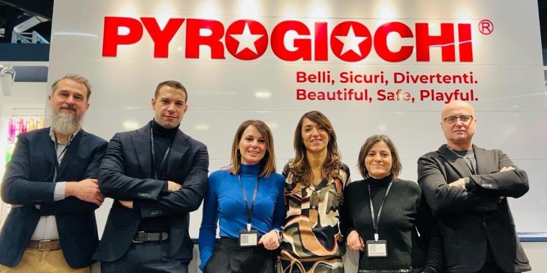 Gruppo di persone in posa davanti a un'insegna di Pyrogiochi alla Spielwarenmesse 2024.