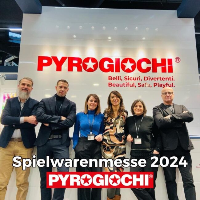 Pyrogiochi Spielwarenmess 2024 Gruppo di persone in posa davanti a un'insegna di Pyrogiochi alla Spielwarenmesse 2024.